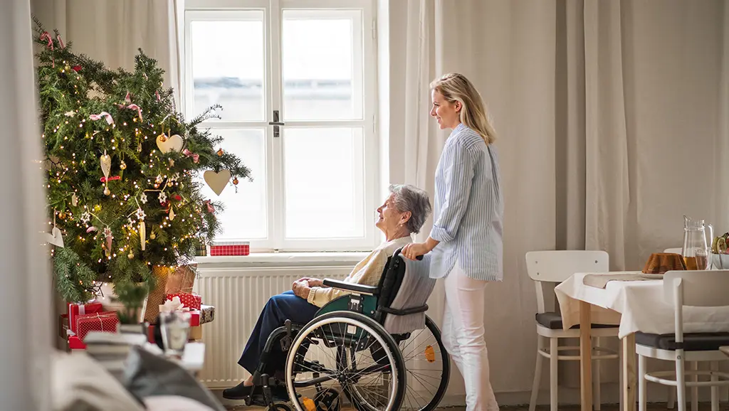 Ältere Frau im Rollstuhl, welche die Weihnachtszeit dank Pflege zuhause verbringen kann
